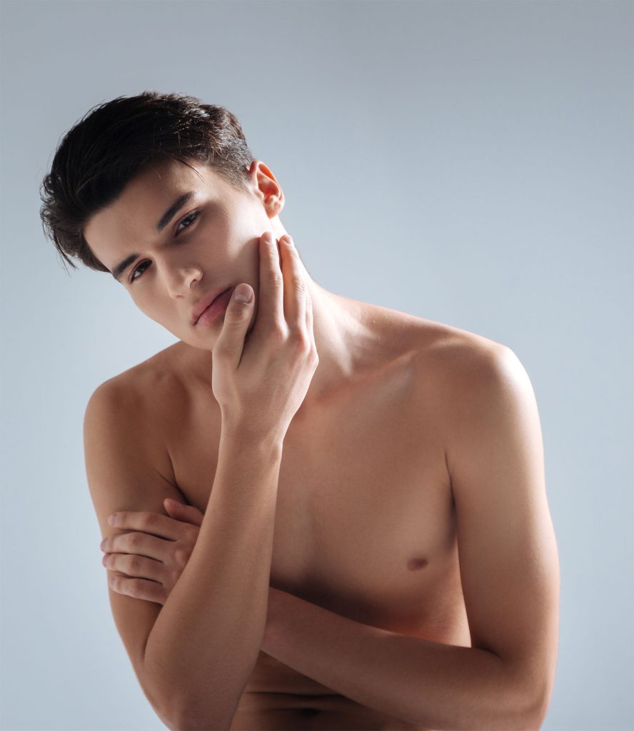A man with his hand on his face posing as a model for facial sculpting.